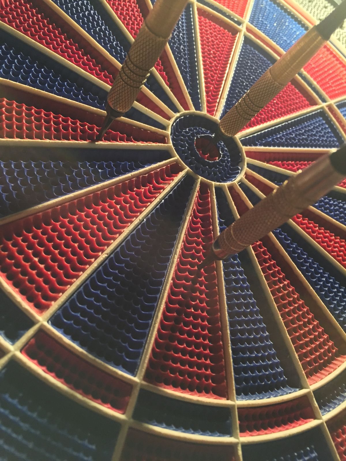 Dartboard mit Pfeilen im Bullseye, präziser Sport-Moment