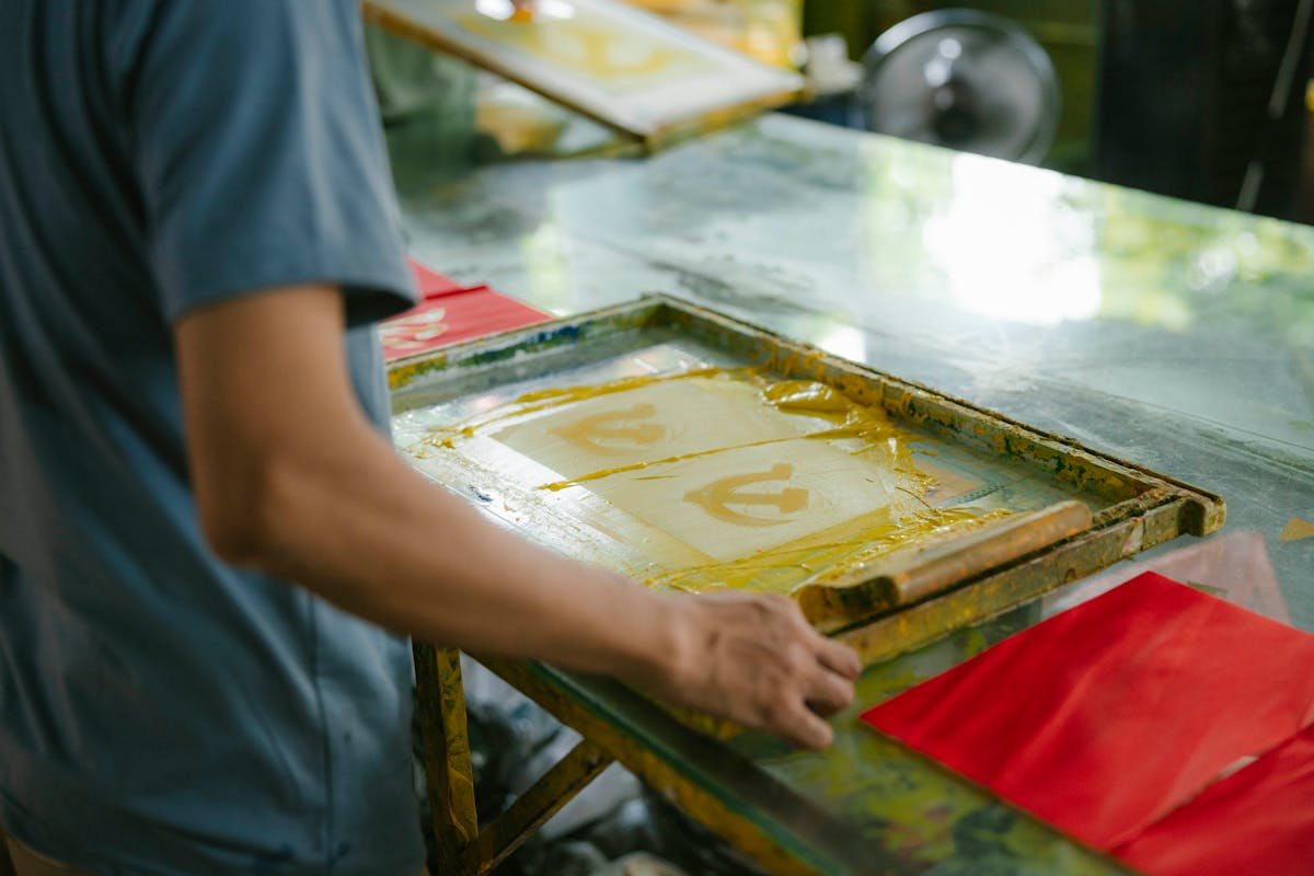 Handwerker an der Siebdruckmaschine, atmosphärische Werkstatt